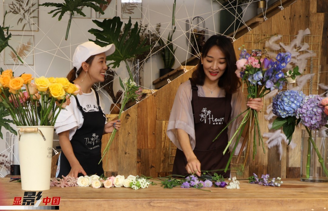 “昆明是鮮花的原產(chǎn)地，有亞洲最大的鮮切花交易市場(chǎng)，可以說具備開花店的天時(shí)地利；另外和很多女孩一樣，我從小也就有開花店的夢(mèng)想！”說起當(dāng)初的決定，王黎媛說一是因?yàn)閴?mèng)想，另外也跟昆明這個(gè)城市產(chǎn)花、賣花的“基因”有關(guān)。圖為王黎媛和同事在制作花束。新華網(wǎng) 周亞平/攝 念新洪/文